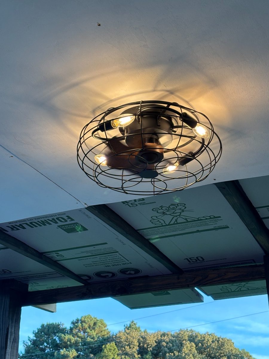 Outdoor ceiling light fixture under a covered porch.